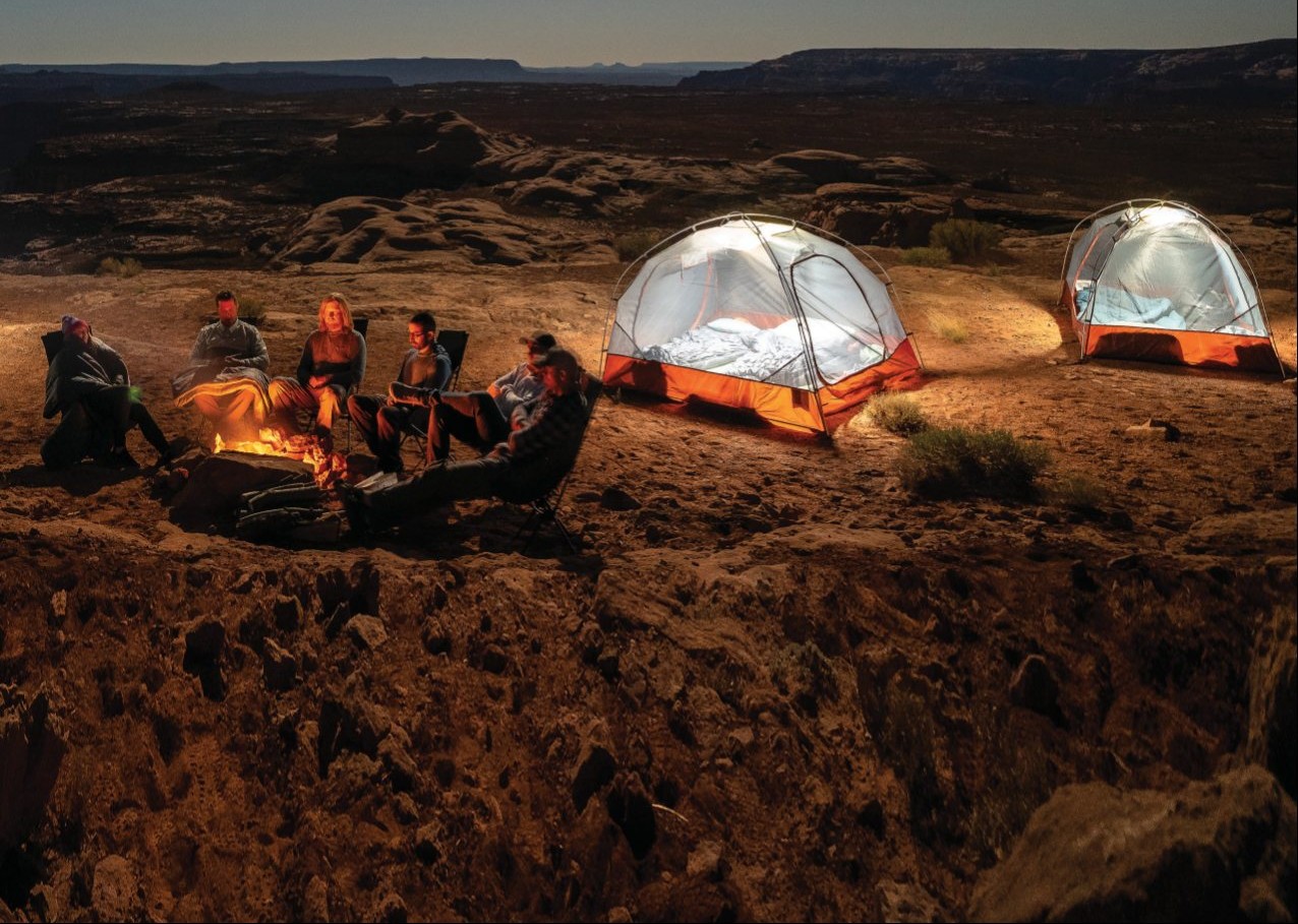 Campers around a fire at dusk