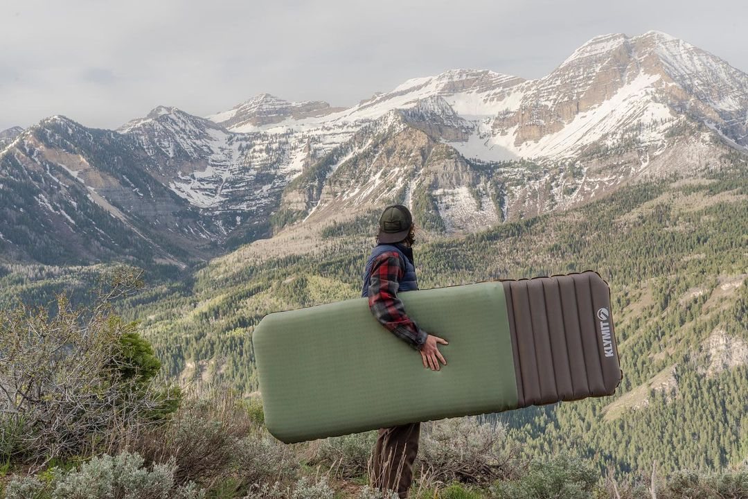 A person carrying gear through the mountains